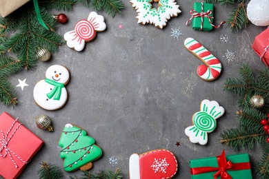 Frame of decorated Christmas cookies and gift boxes on grey table, flat lay. Space for text