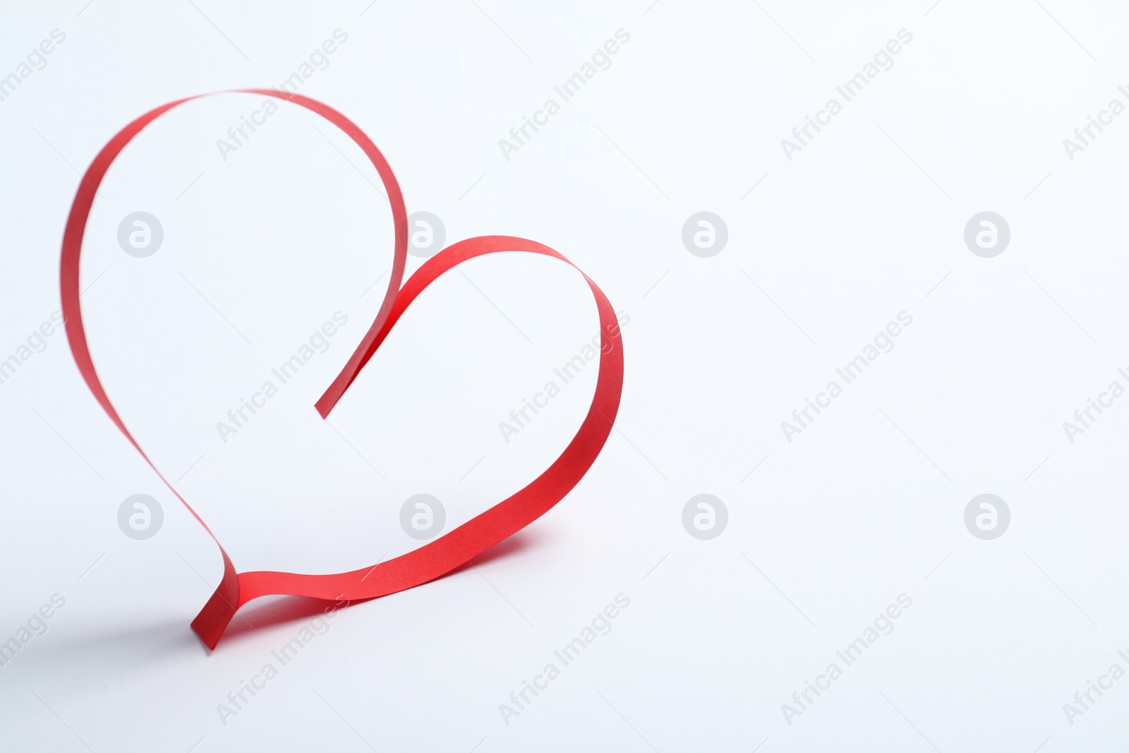 Photo of Heart made of paper strips on white background. Space for text