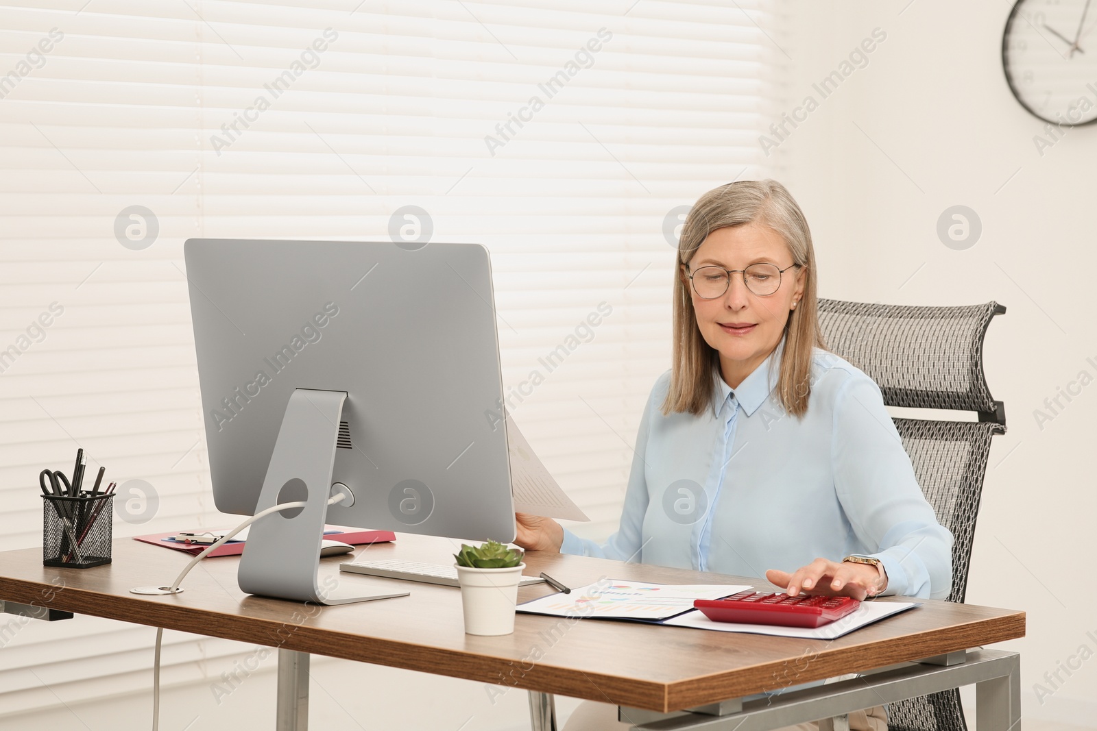 Photo of Senior accountant working at wooden desk in office