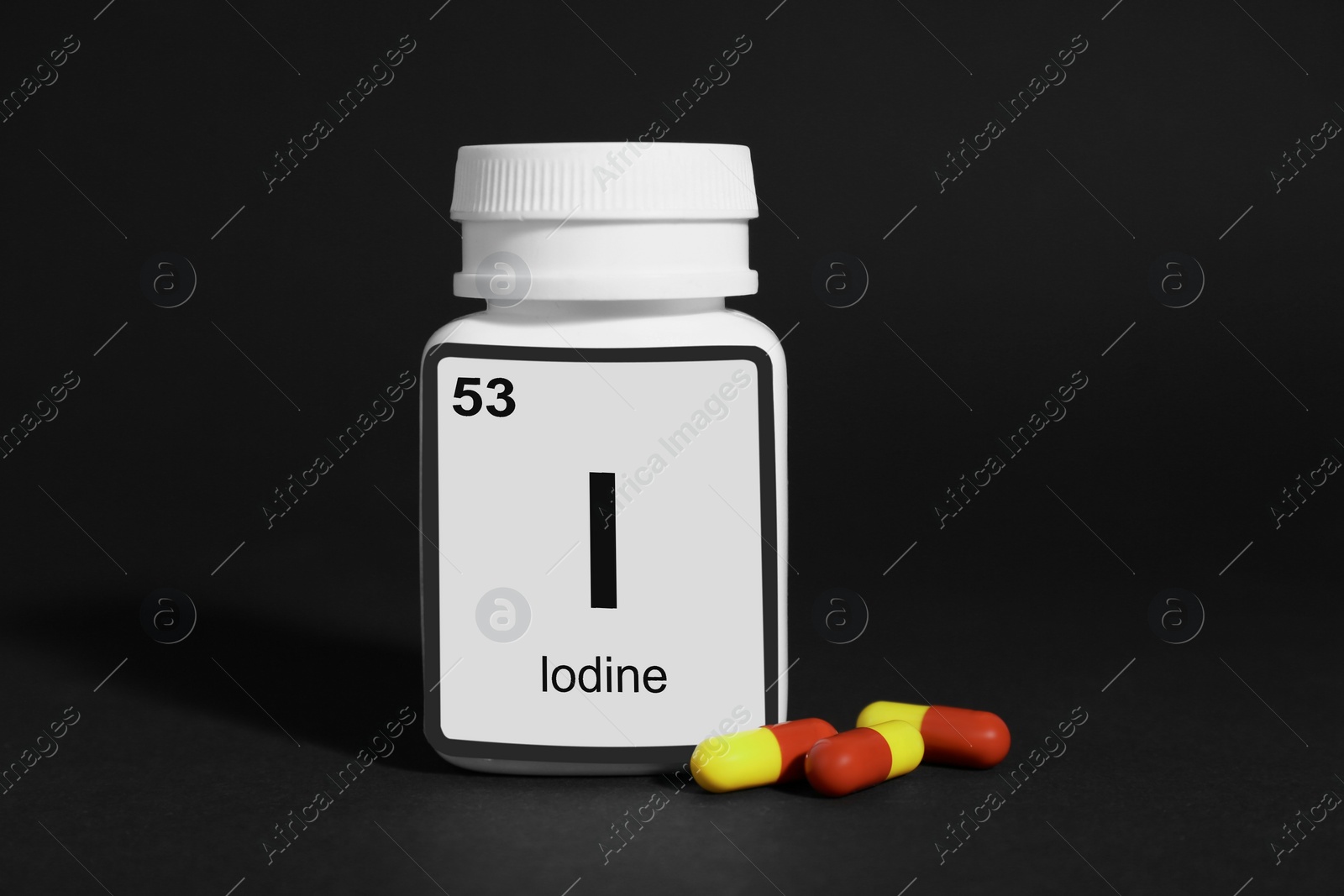 Photo of Bottle of medical iodine and pills on black background