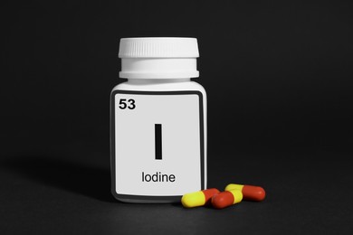 Photo of Bottlemedical iodine and pills on black background
