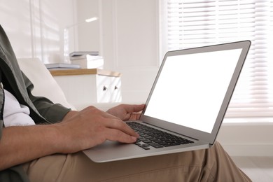 Photo of Man with modern laptop indoors, closeup. Space for design