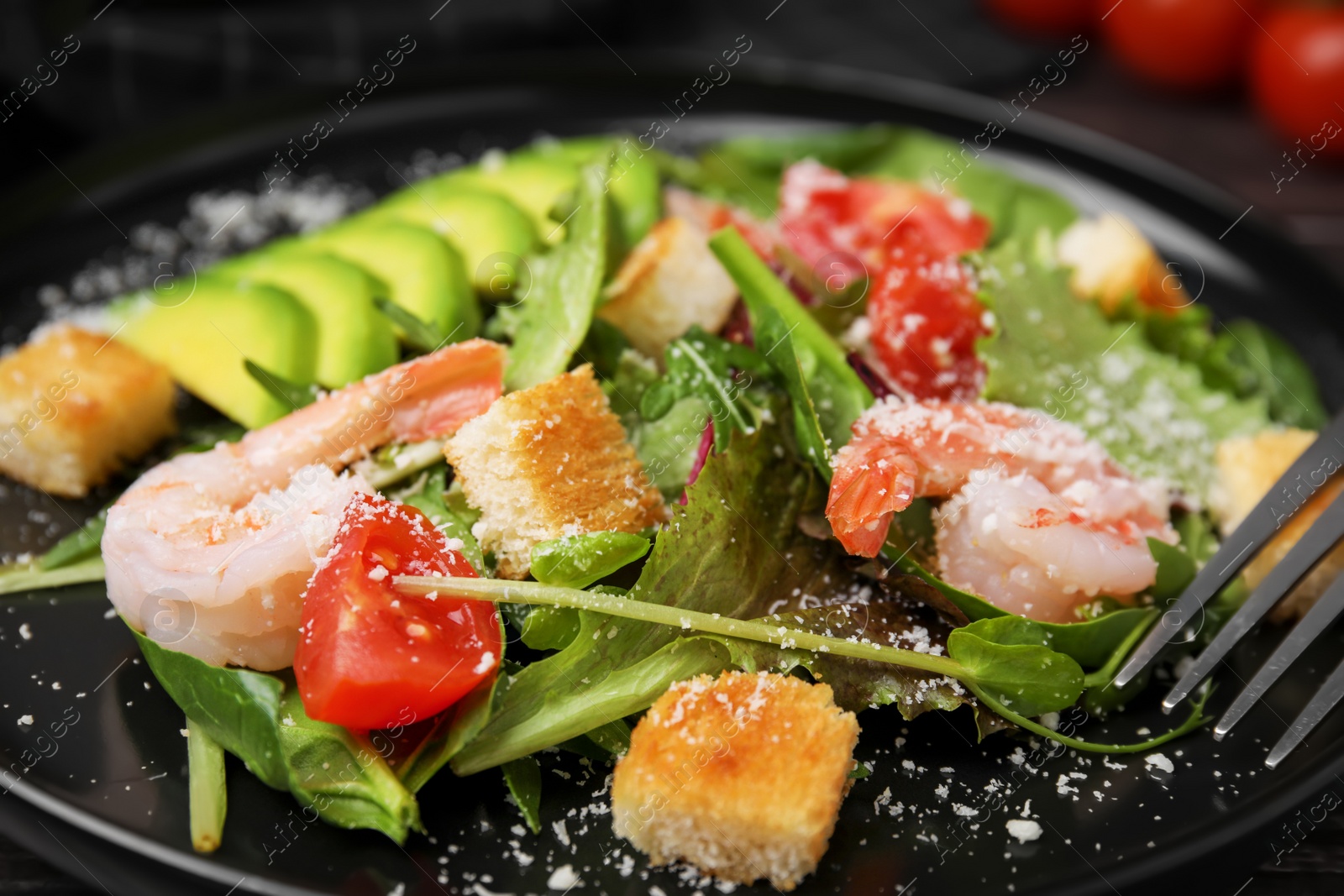 Photo of Delicious salad with croutons, avocado and shrimp served on table, closeup