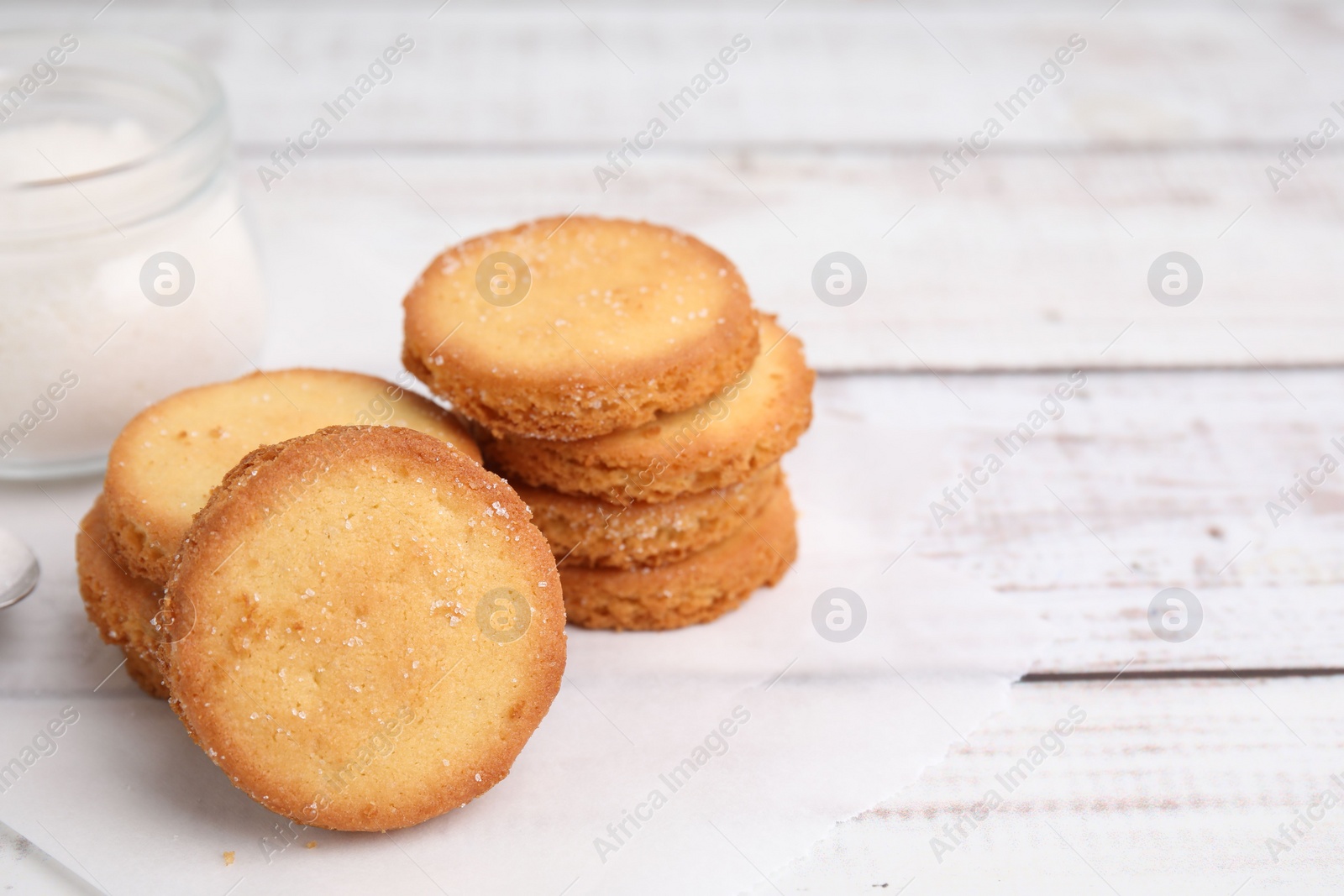 Photo of Tasty sweet sugar cookies on white wooden table, closeup. Space for text