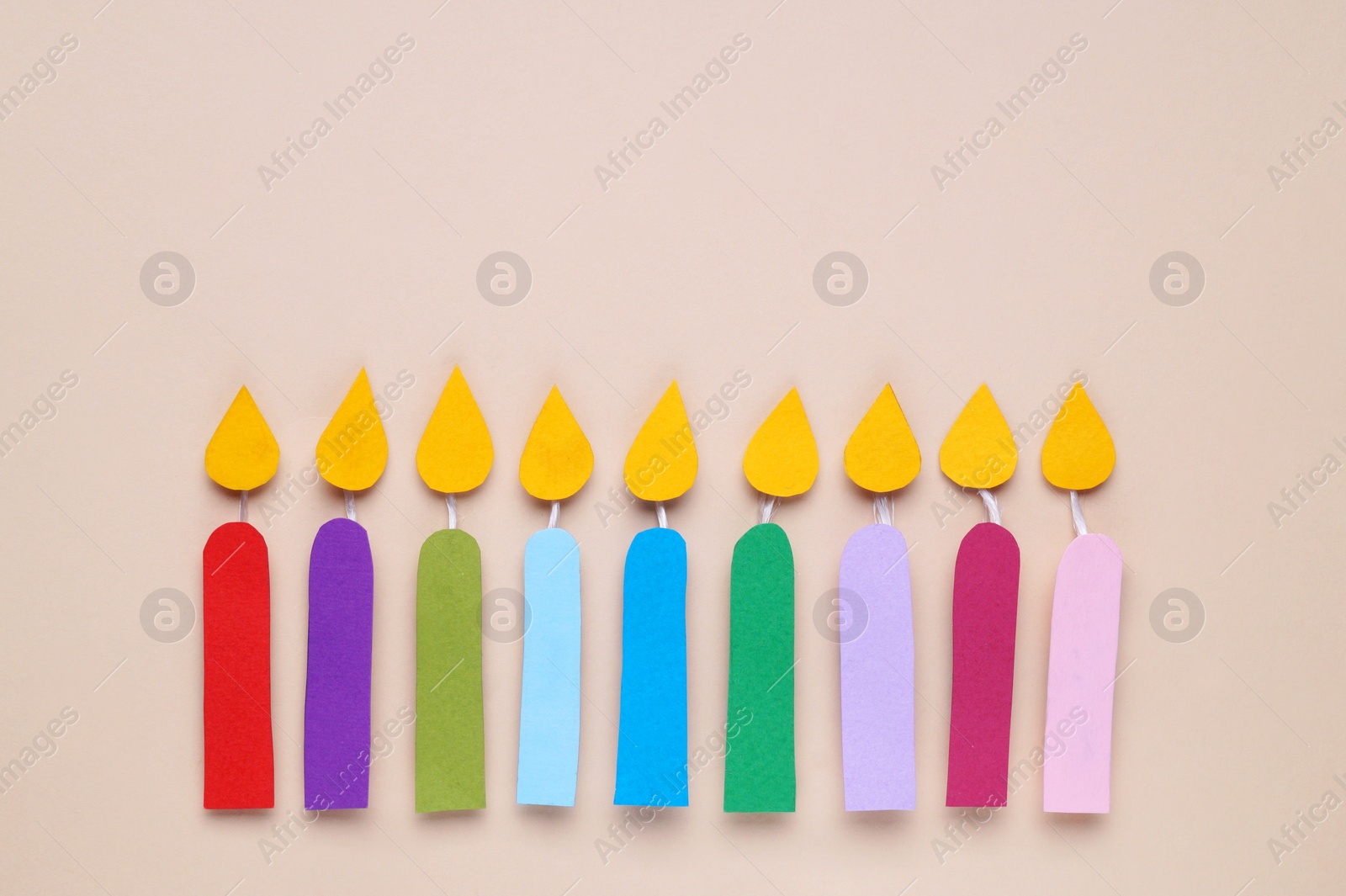 Photo of Different paper candles on beige background, flat lay