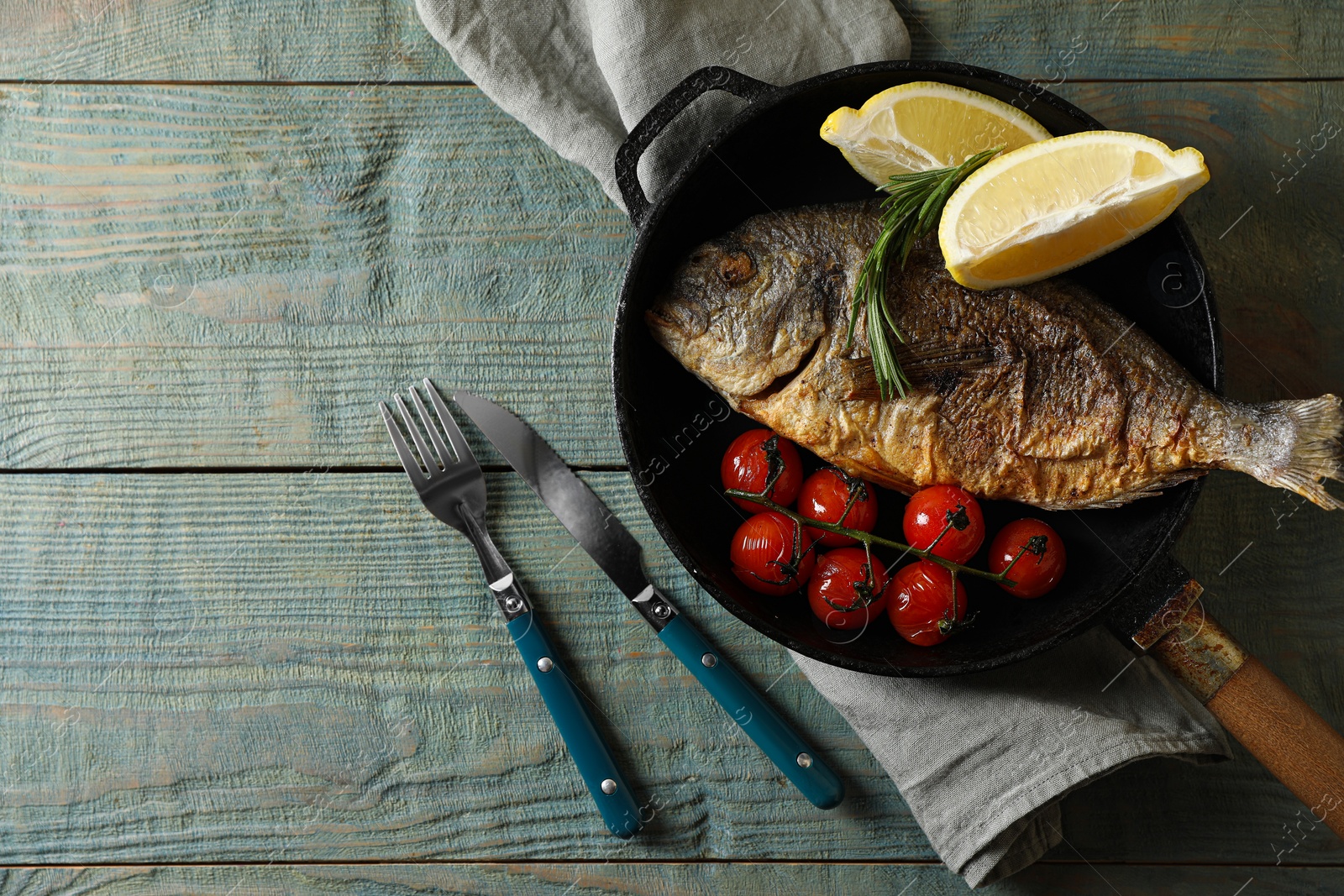 Photo of Delicious dorado fish served on wooden table, flat lay. Space for text