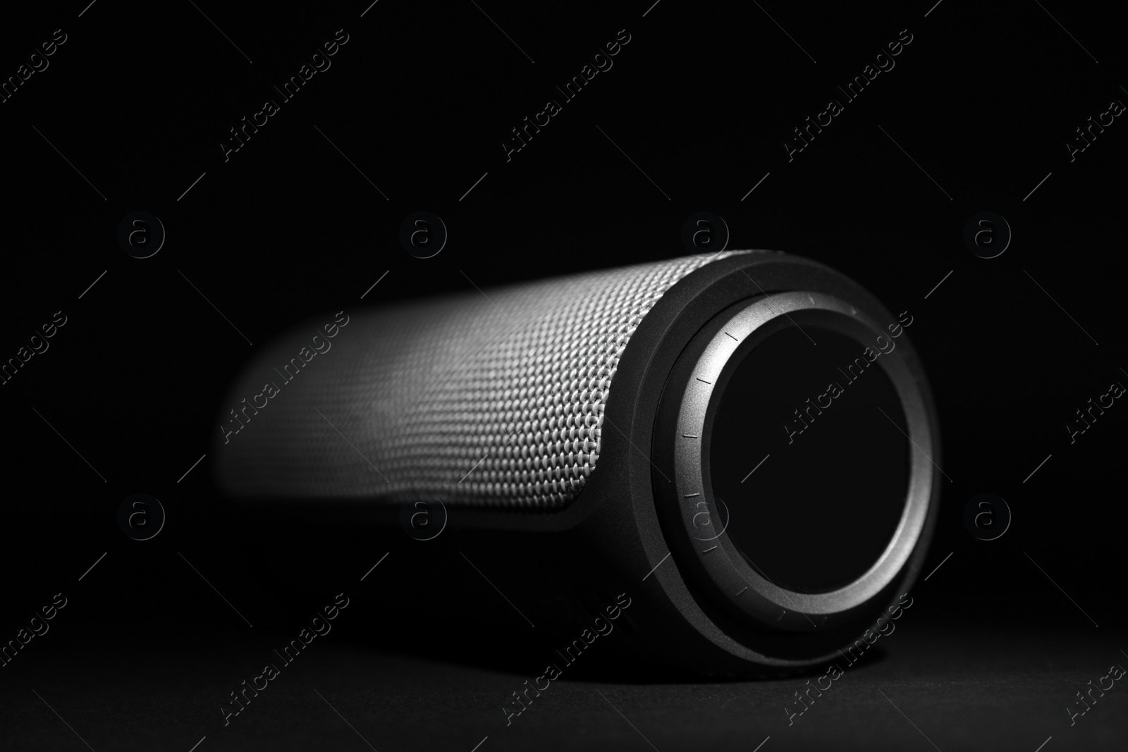 Photo of One portable bluetooth speaker on black background, closeup. Audio equipment