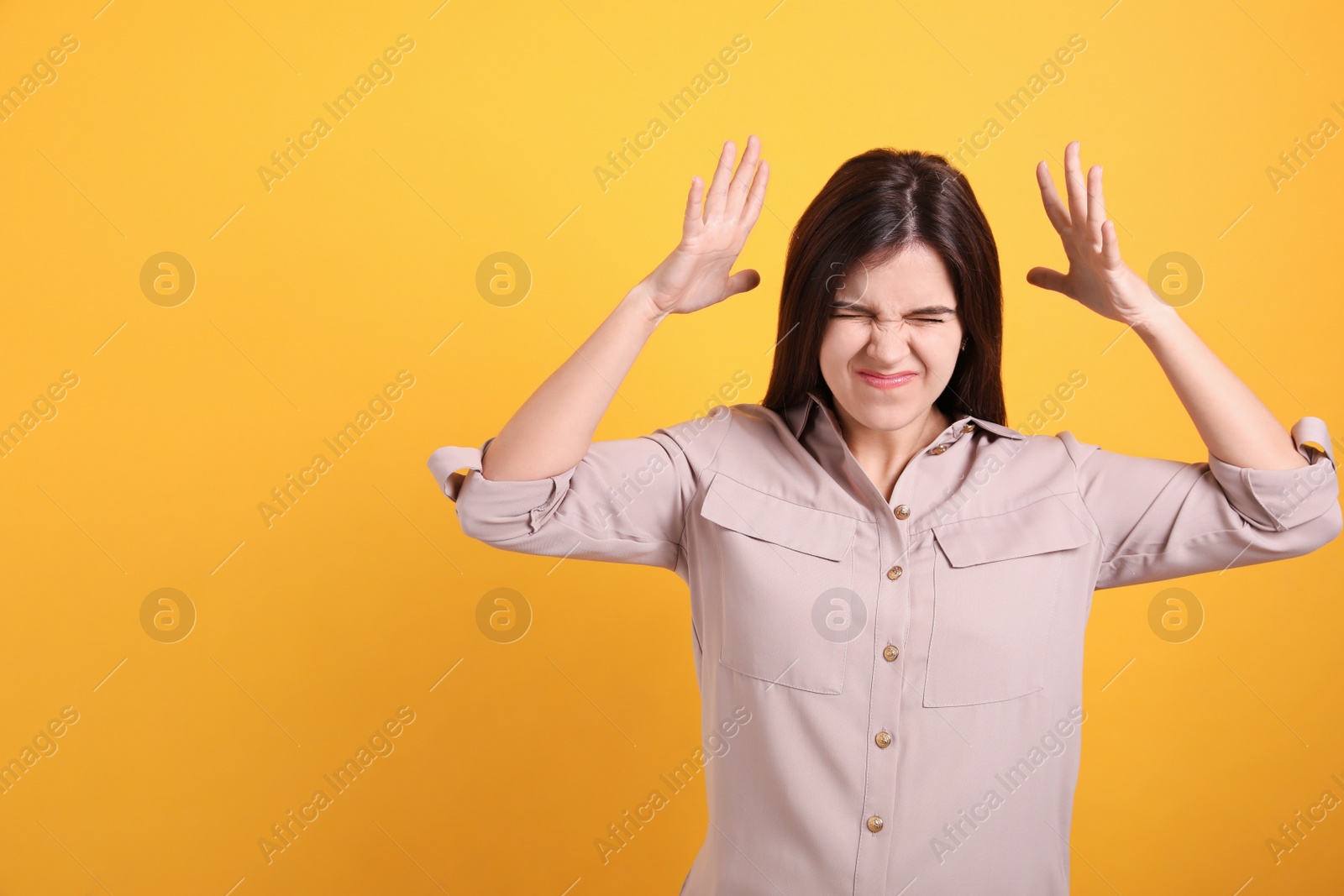 Photo of Portrait of stressed young woman on yellow background. Space for text