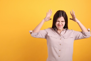 Photo of Portrait of stressed young woman on yellow background. Space for text