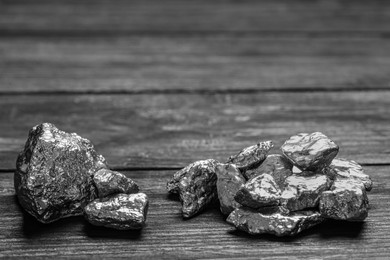 Pile of silver nuggets on black wooden table. Space for text