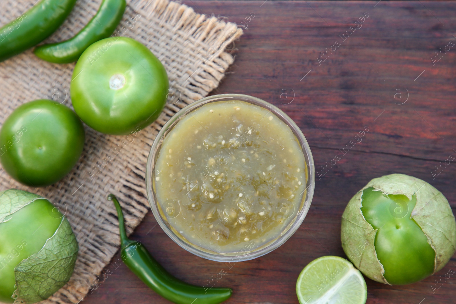 Photo of Tasty salsa sauce and ingredients on wooden table, flat lay