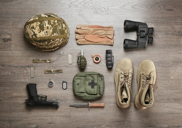 Photo of Set of military equipment and combat boots on wooden background, flat lay