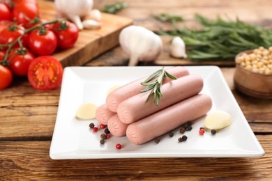 Fresh raw vegetarian sausages with rosemary, garlic and pepper on wooden table