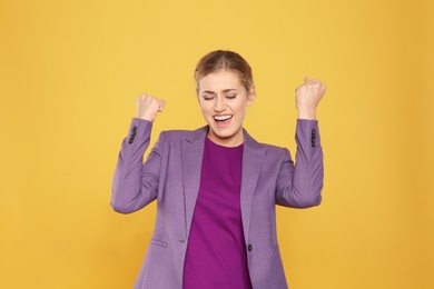 Photo of Happy young businesswoman celebrating victory on color background