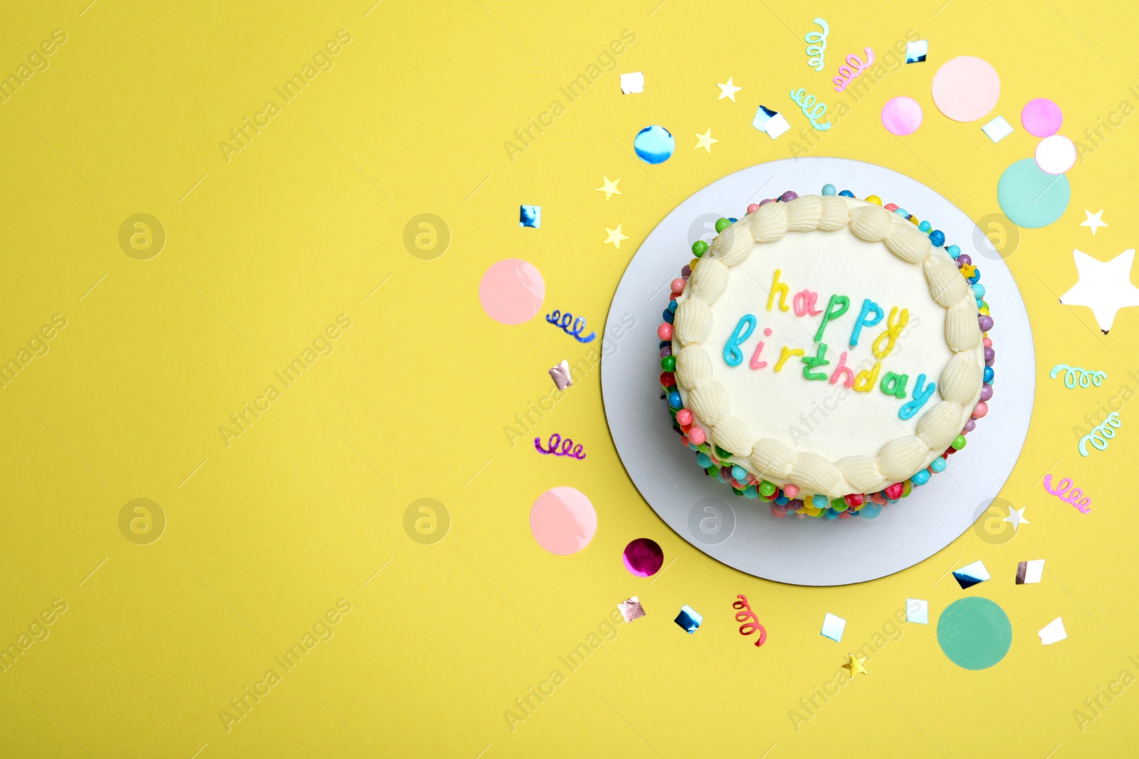 Photo of Cute bento cake with tasty cream and confetti on yellow background, flat lay. Space for text