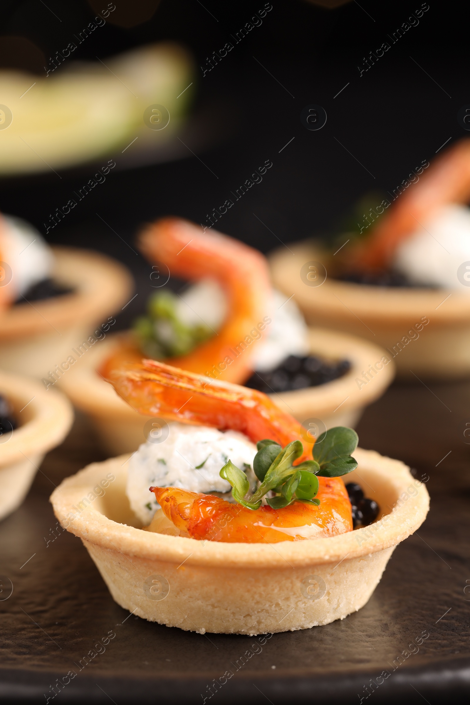 Photo of Delicious canapes with shrimps and black caviar on table, closeup