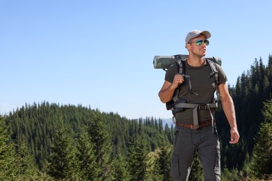 Photo of Tourist with backpack in mountains on sunny day. Space for text