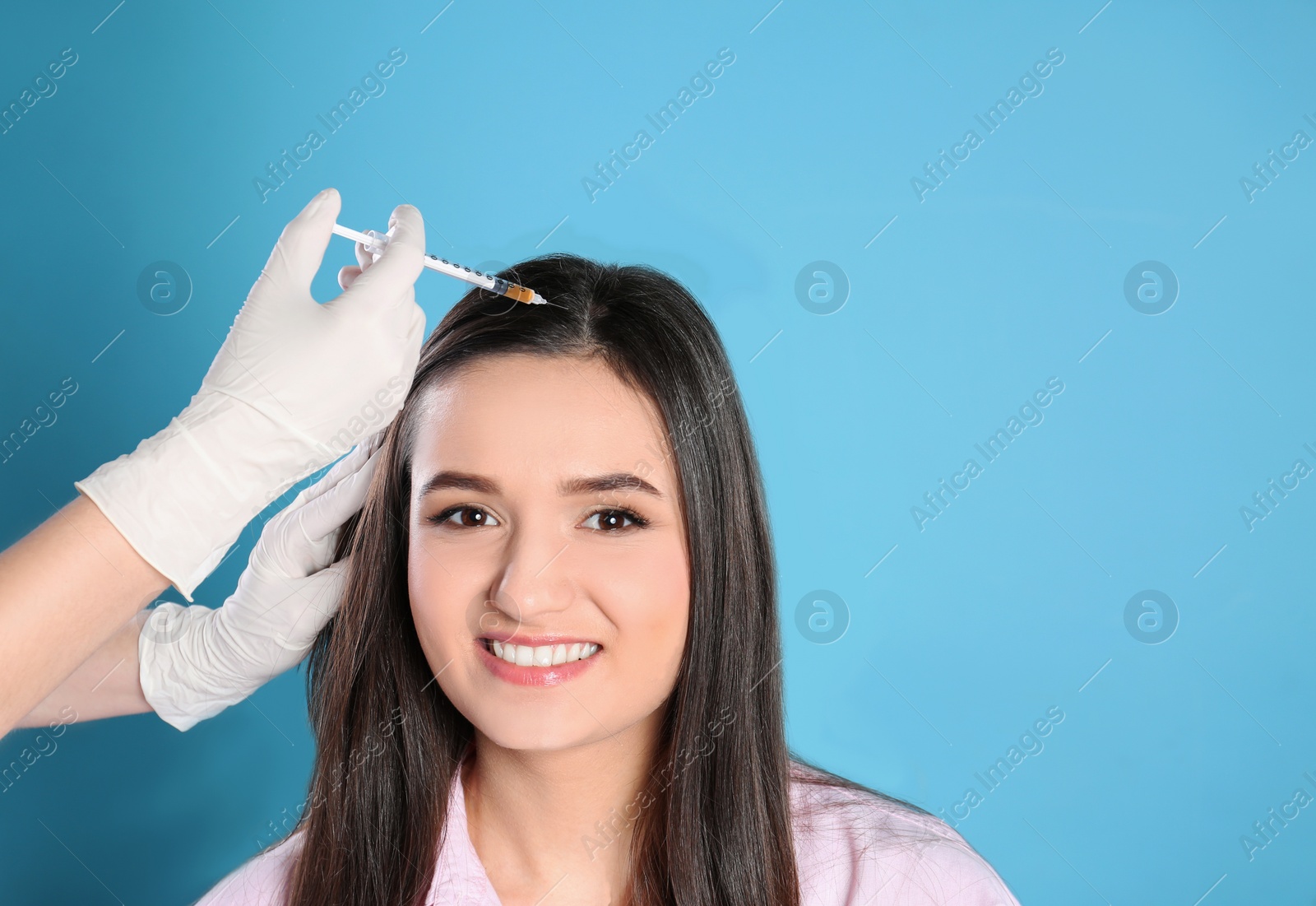 Photo of Young woman with hair loss problem receiving injection on color background. Space for text