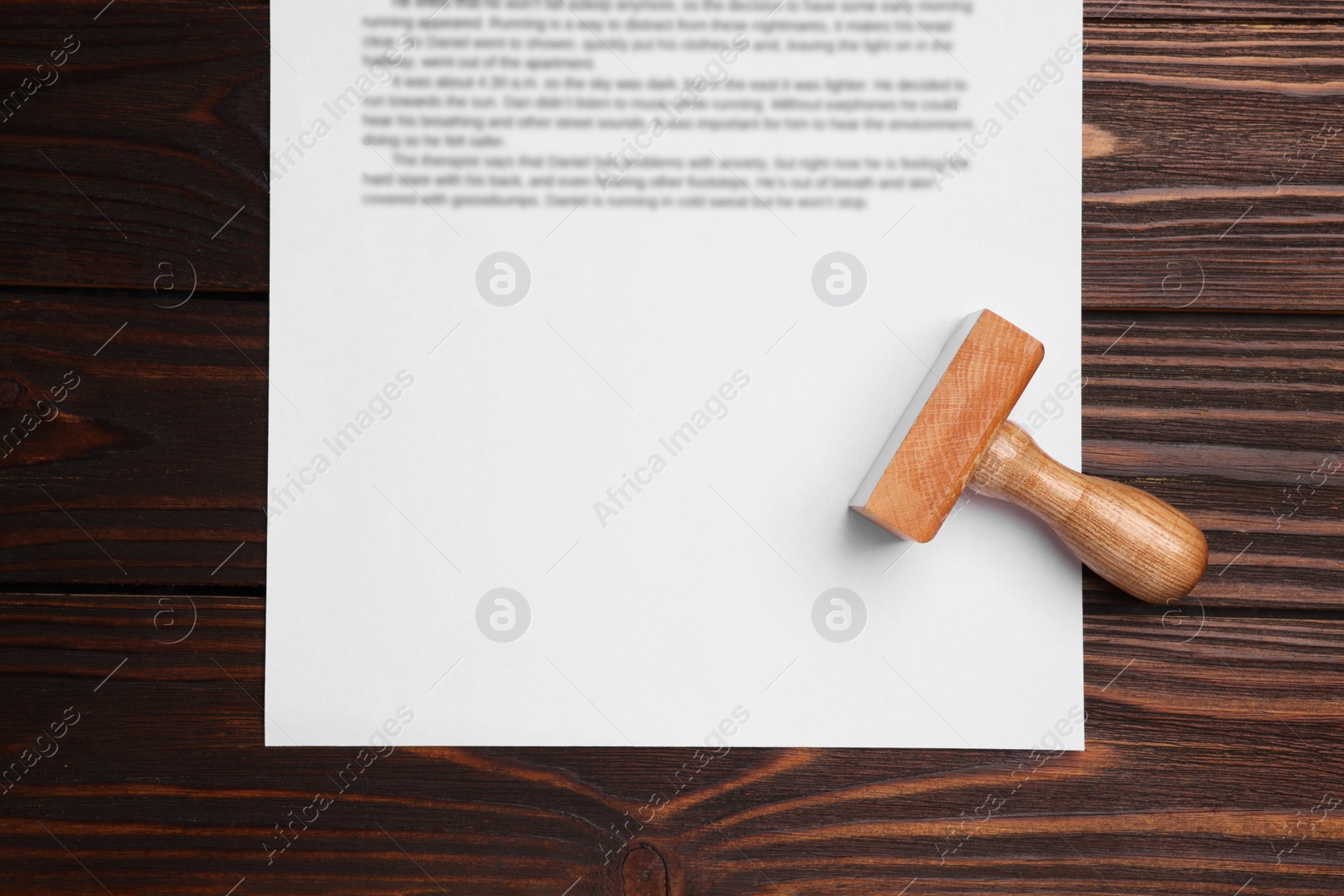 Photo of One stamp tool and document on wooden table, top view