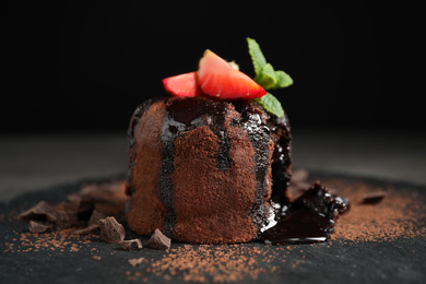 Photo of Delicious warm chocolate lava cake on slate board, closeup