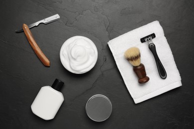 Set of men's shaving tools on black textured table, flat lay