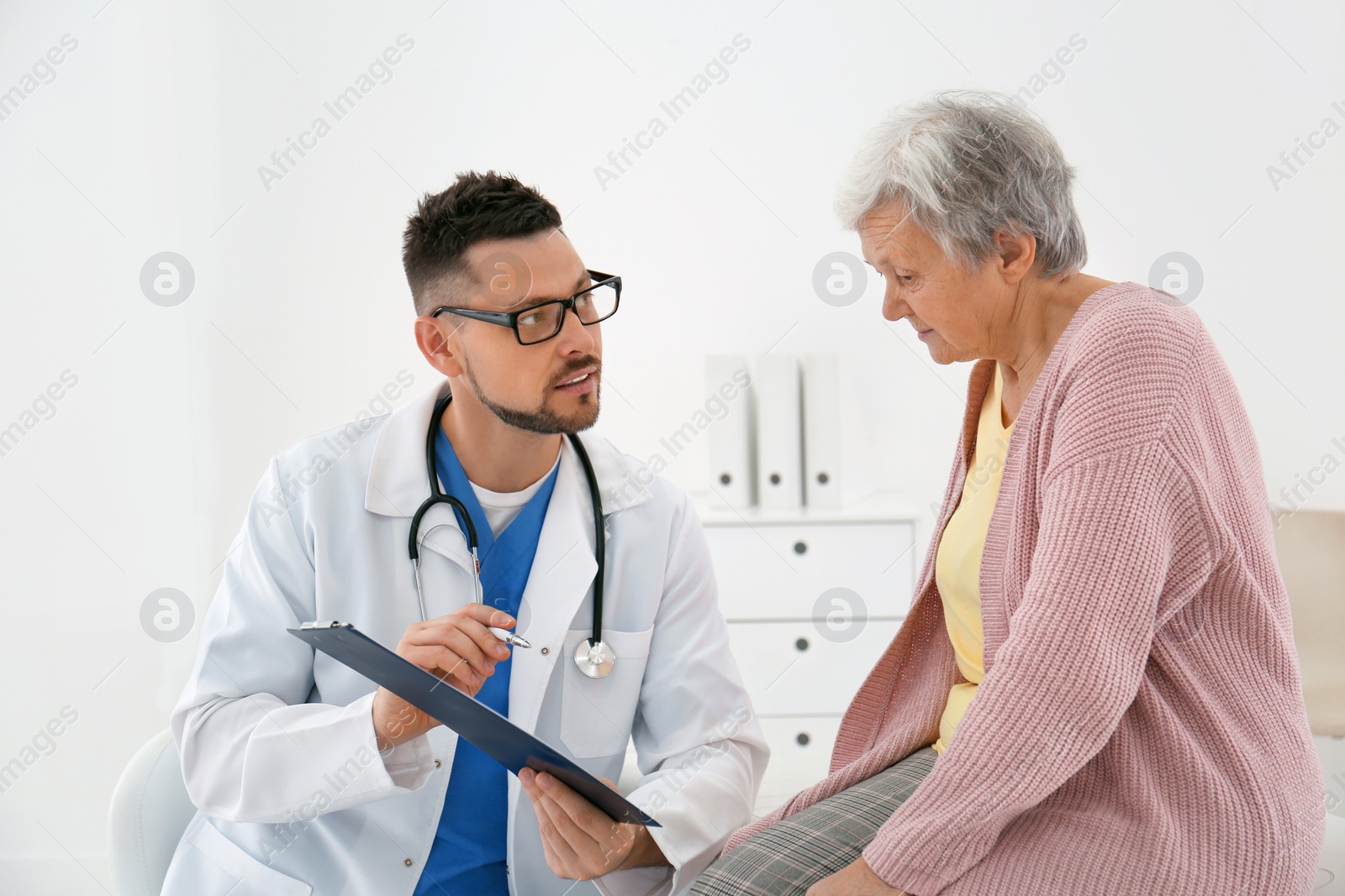 Photo of Doctor with senior patient in modern office