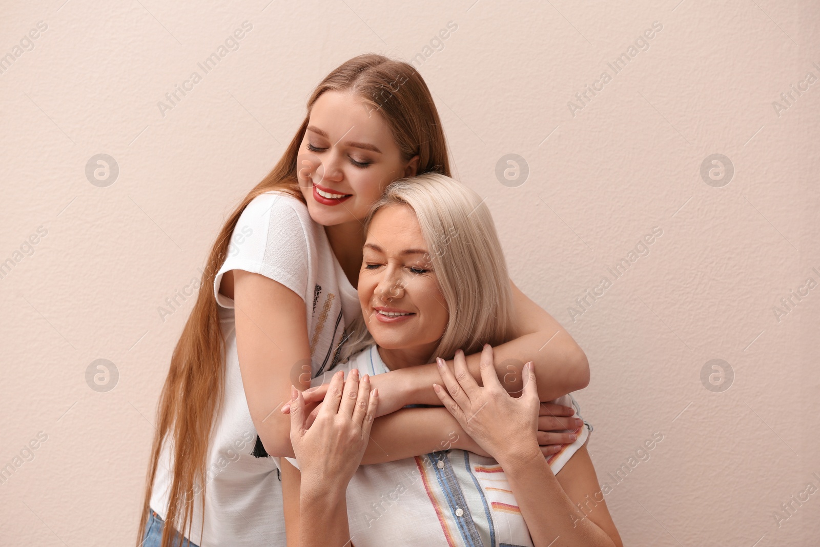 Photo of Mother and her adult daughter on beige background