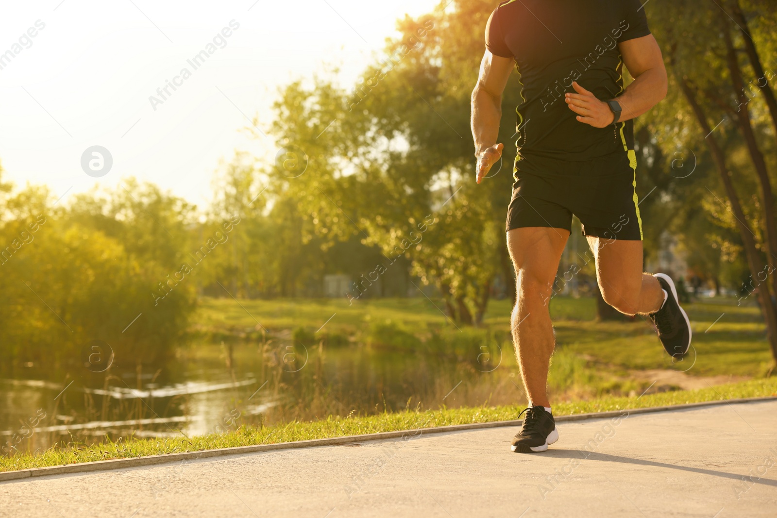 Photo of Man running near pond in park, closeup. Space for text