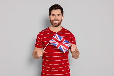 Photo of Man with flag of United Kingdom on light grey background