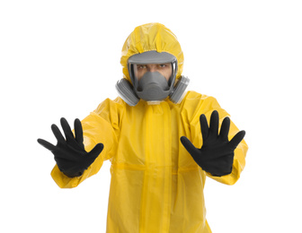 Photo of Man wearing chemical protective suit showing STOP gesture on white background. Prevention of virus spread