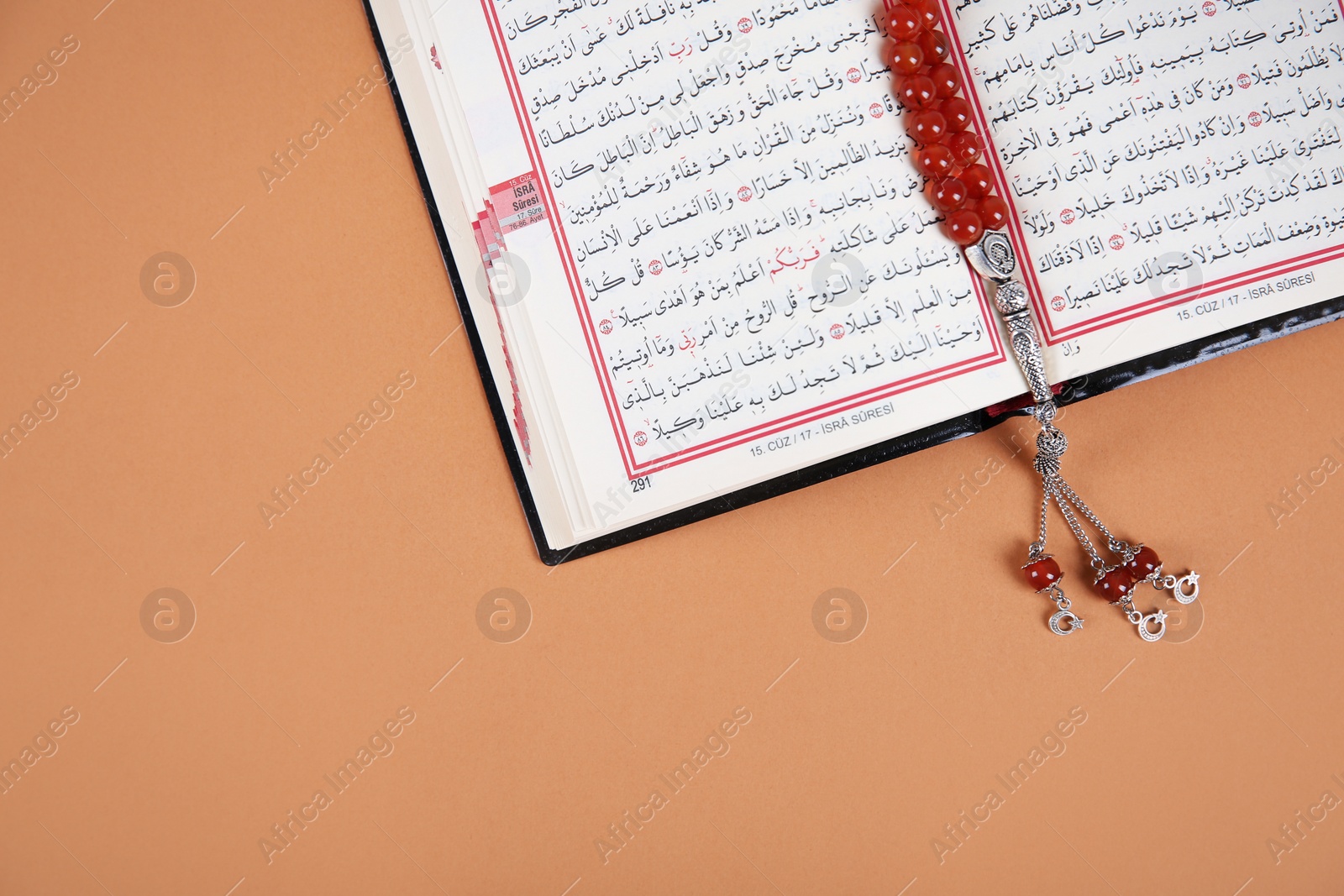 Photo of Muslim prayer beads, Quran and space for text on color background, top view