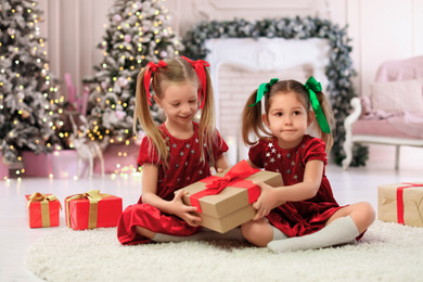 Photo of Cute little children with Christmas gifts at home