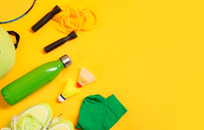 Different sports equipment on yellow background, flat lay. Space for text