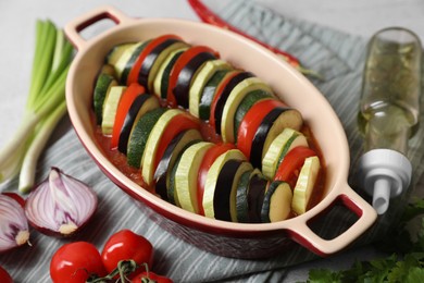 Cooking delicious ratatouille. Dish with different cut vegetables on table, closeup