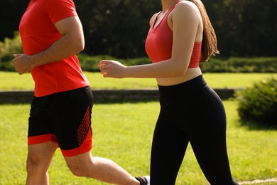 Photo of Healthy lifestyle. Couple running in park on sunny day, closeup