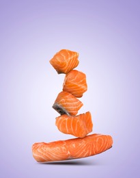 Image of Cut fresh salmon falling on violet gradient background