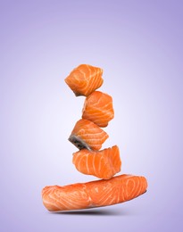 Cut fresh salmon falling on violet gradient background