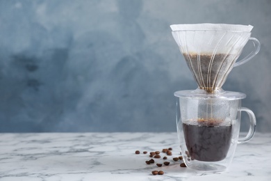 Photo of Brewing tasty coffee using drip filter on white marble table. Space for text