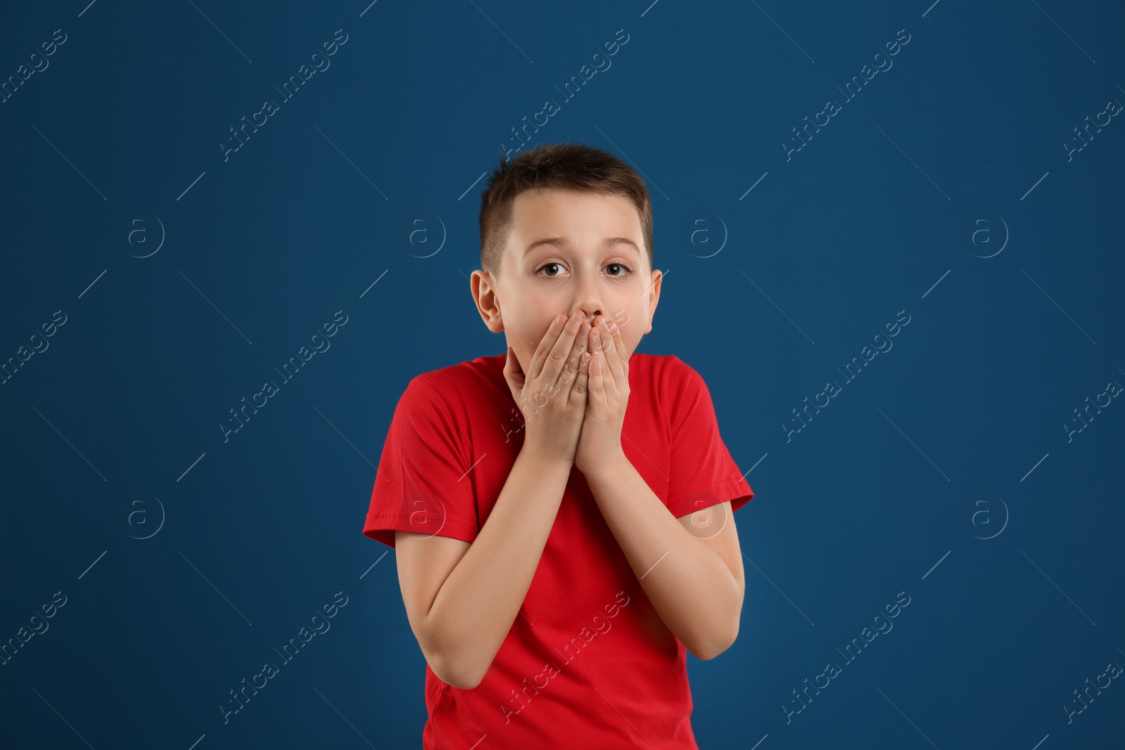 Photo of Portrait of emotional preteen boy on blue background