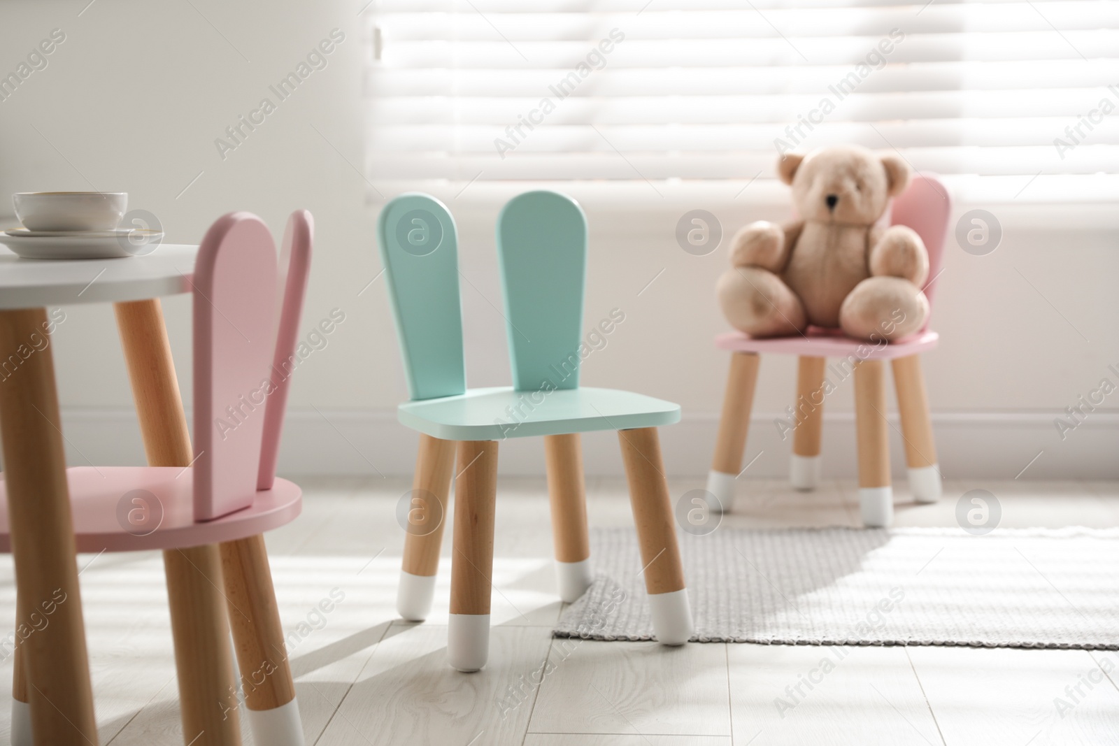 Photo of Cute little chair with bunny ears indoors. Children's room interior