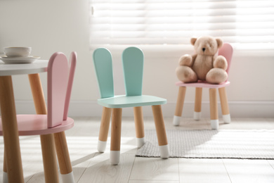 Cute little chair with bunny ears indoors. Children's room interior