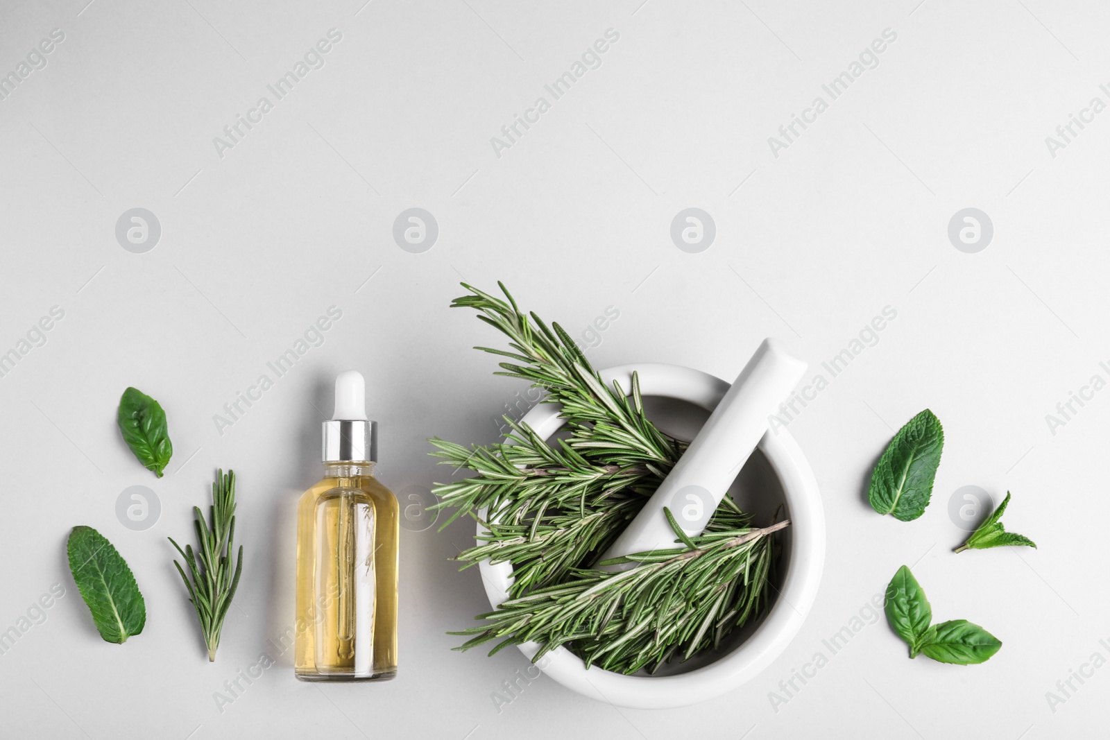 Photo of Flat lay composition with herbal essential oil and space for text on light background