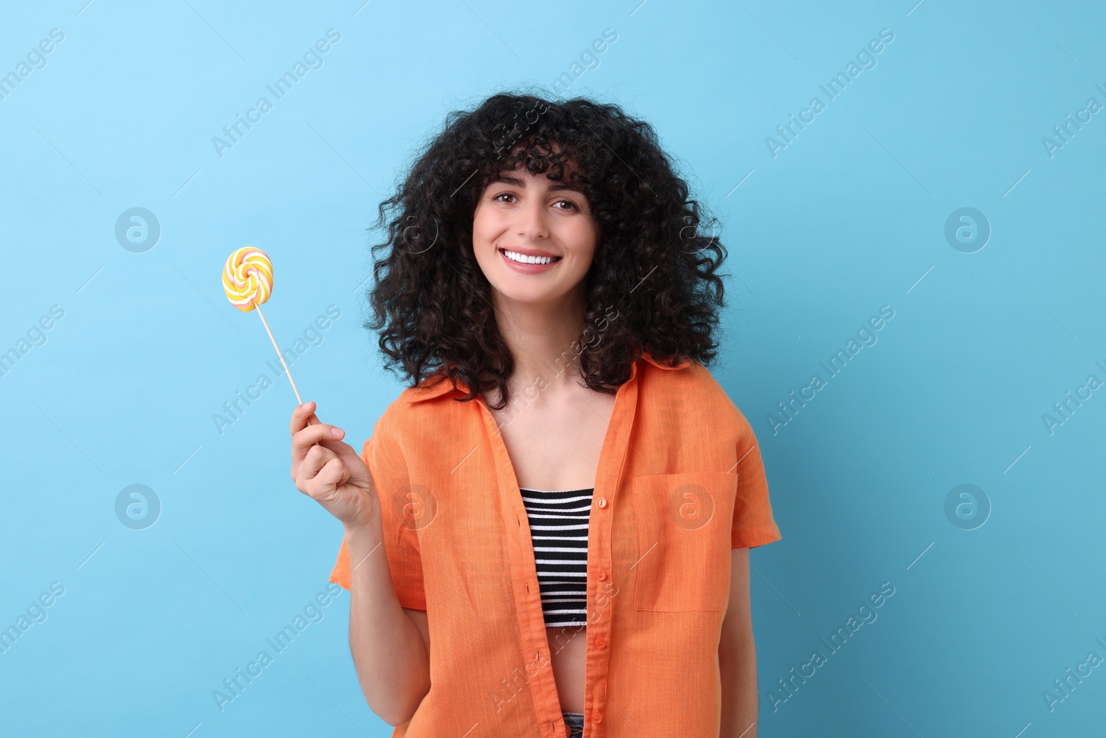 Photo of Beautiful woman with lollipop on light blue background