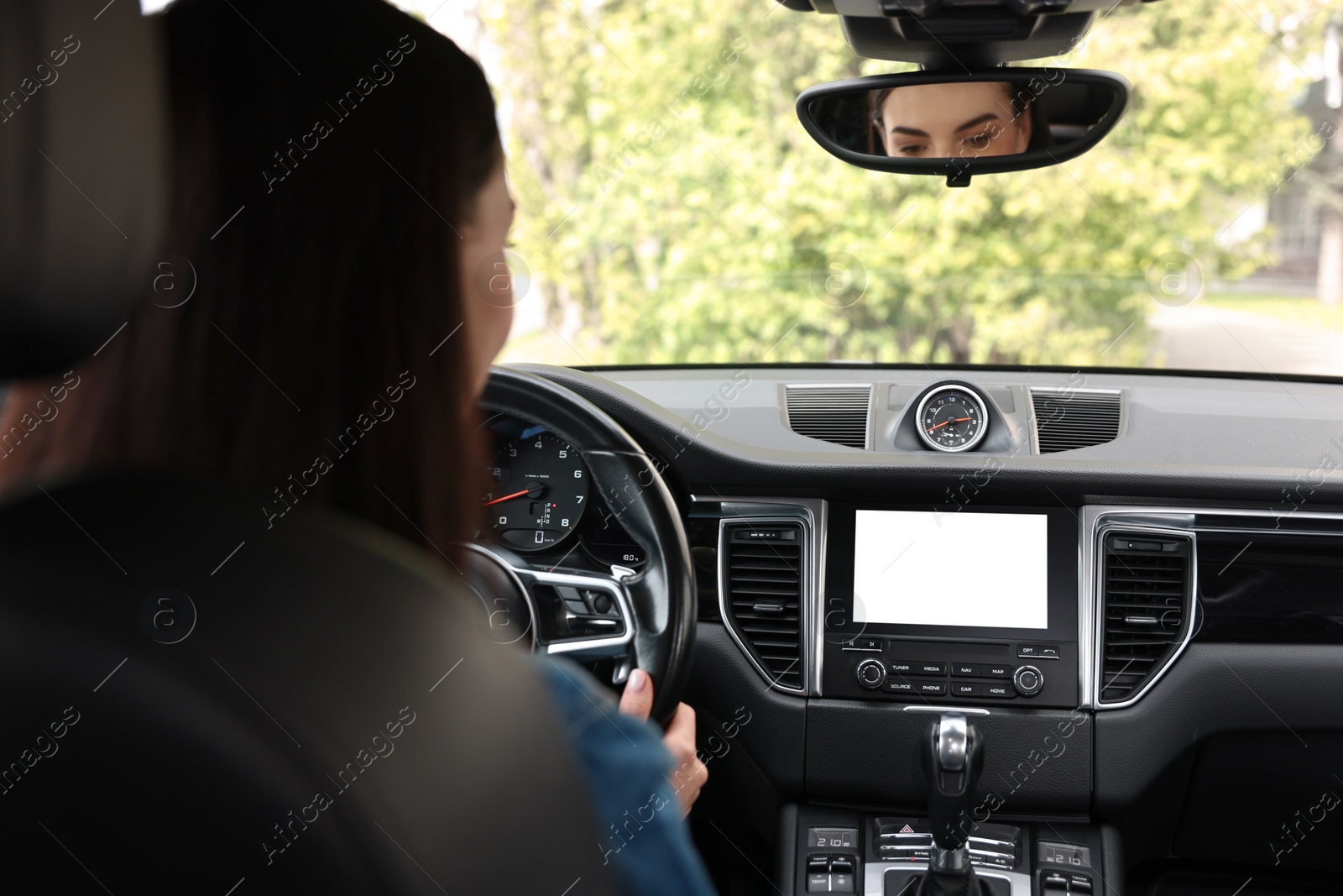 Photo of Woman using navigation system while driving her car, closeup