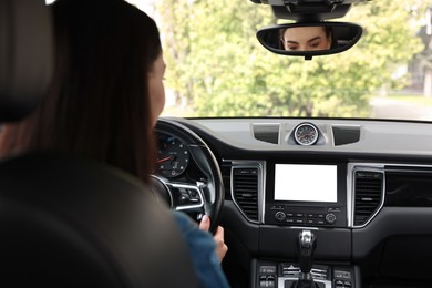 Photo of Woman using navigation system while driving her car, closeup