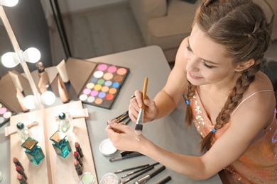 Photo of Portrait of beautiful woman applying makeup indoors