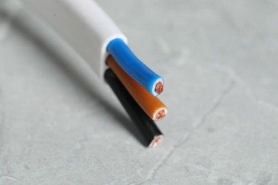 Colorful electrical wire on gray surface, closeup