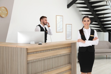 Photo of Young receptionists in professional uniform at workplace