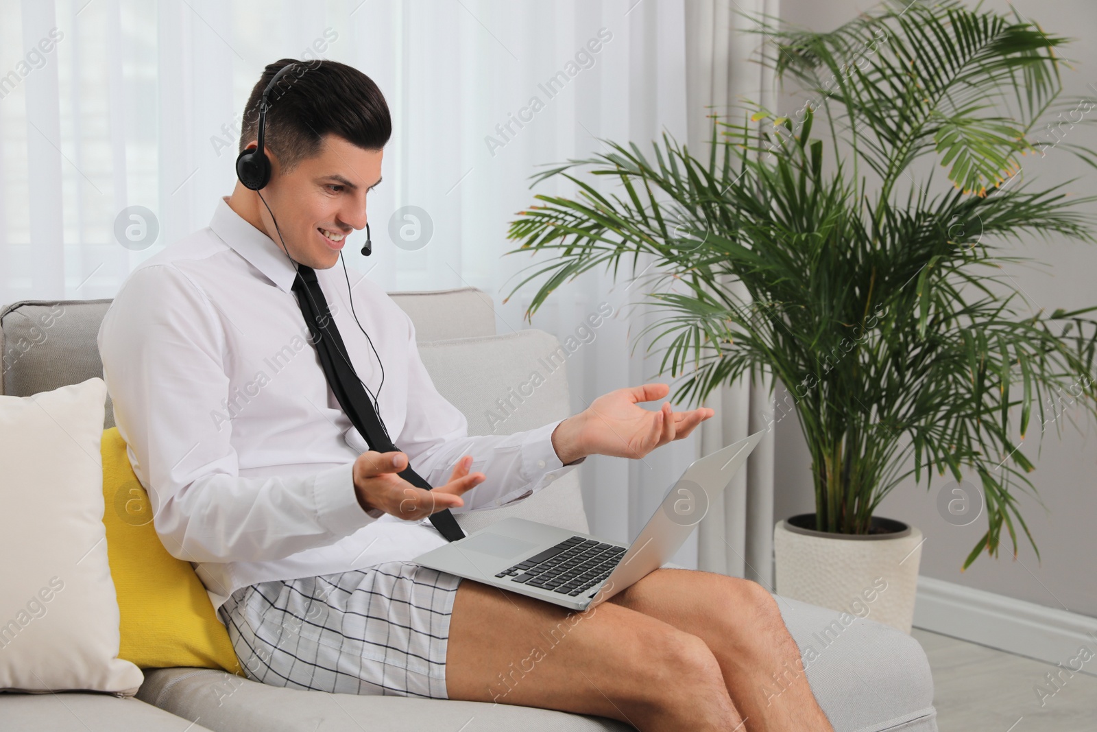 Photo of Man working on laptop in living room. Stay at home concept