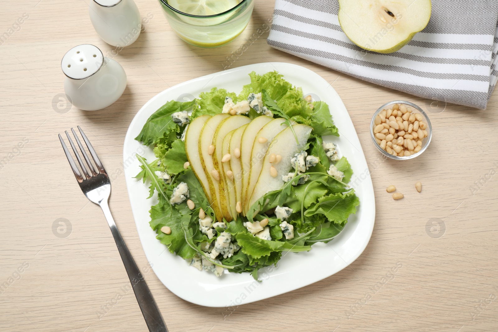 Photo of Fresh salad with pear served on wooden table, flat lay